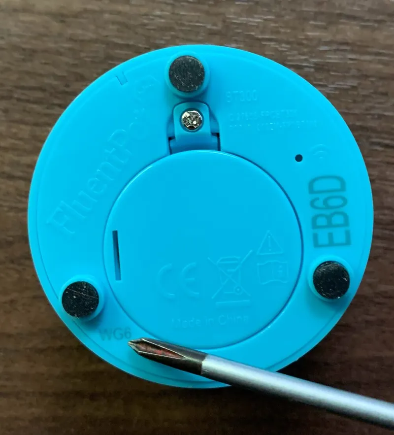 The bottom of a Connect Button, with a screwdriver tip pointing at the batch code at the lower left.